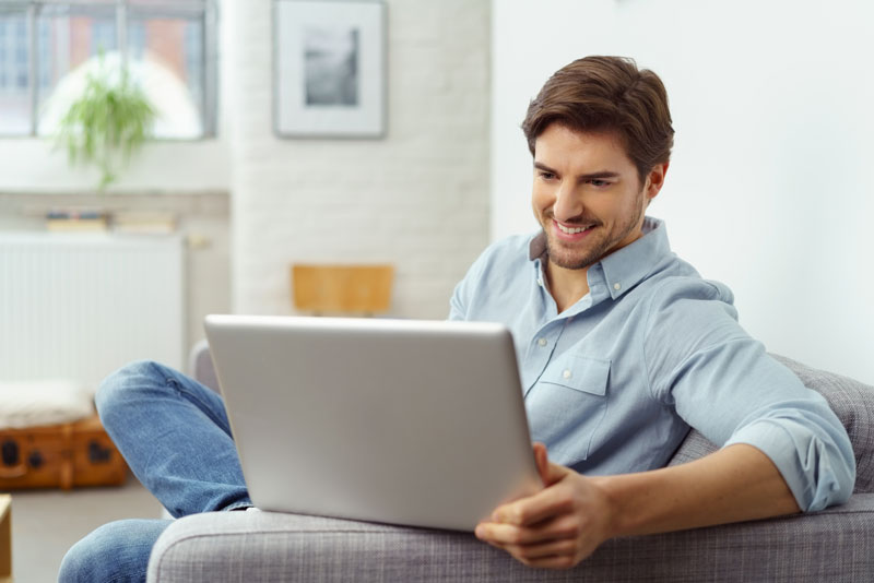 Man smiling using laptop